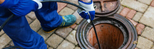 sewer cleaning service - worker clean a clogged drainage with hydro jetting