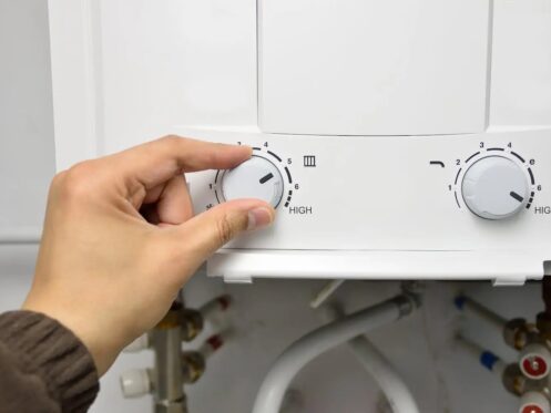 Close up of a person adjusting the settings on a tankless water heater